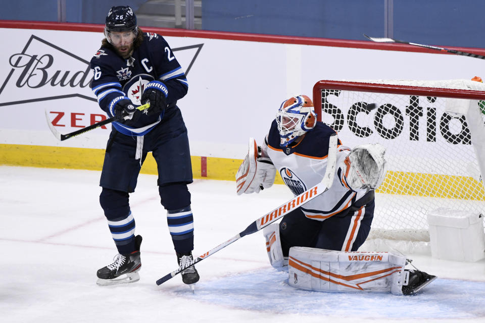 Edmonton Oilers' goaltender Mikko Koskinen (19) loses his stick as the shot is deflected by Winnipeg Jets' Blake Wheeler (26) during the second period of an NHL hockey game Tuesday, Jan. 26, 2021, in Winnipeg, Manitoba. (Fred Greenslade/The Canadian Press via AP)