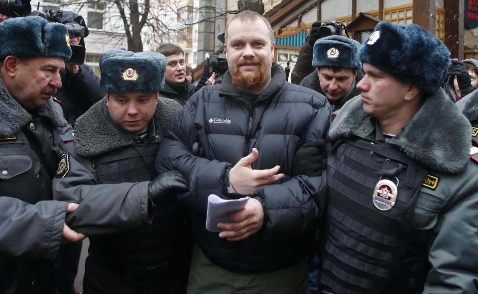 Police officers detain Dmitry Demushkin, the leader of the banned ultra-nationalist group Slavic Union, outside a court where Russian martial arts champion Rasul Mirzaev was found guilty of involuntary manslaughter, Moscow, Russia, Tuesday, Nov. 27, 2012. Mirzayev was sentenced to two years of house arrest over the death of a man he had punched outside a club. (AP Photo/Misha Japaridze)