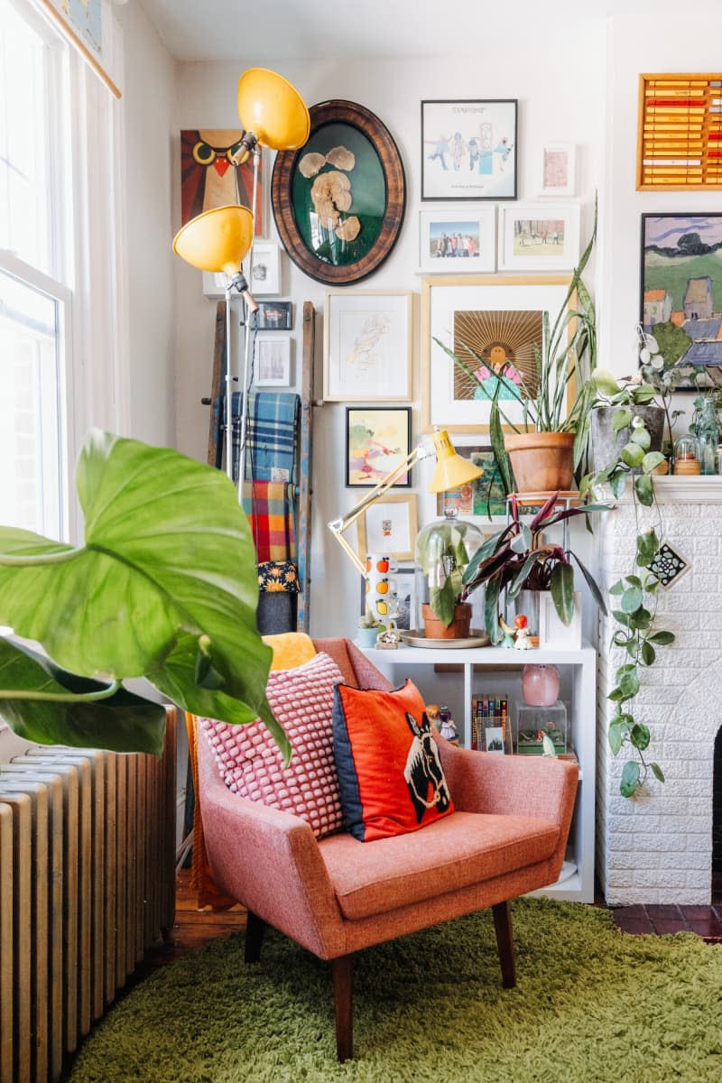 Living room with fabric chair next to a gallery wall of art.