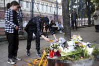 People light candles for the victims near the Vladislav Ribnikar school in Belgrade, Serbia, Wednesday, May 3, 2023. A 13-year-old who opened fire Wednesday at his school in Serbia's capital drew sketches of classrooms and made a list of people he intended to target in a meticulously planned attack, police said. He killed eight fellow students and a guard before calling the police and being arrested. (AP Photo/Armin Durgut)