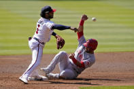 Atlanta Braves second baseman Ozzie Albies (1) throws to first after forcing out Cincinnati Reds' Eugenio Suarez (7) during the second inning in Game 2 of a National League wild-card baseball series, Thursday, Oct. 1, 2020, in Atlanta. The Reds' Mike Moustakas was safe at first. (AP Photo/John Bazemore)