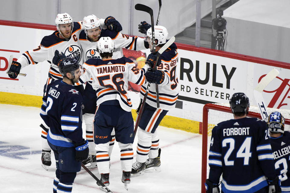 Edmonton Oilers' Leon Draisaitl (29) celebrates his second goal with Connor McDavid (97), Kailer Yamamoto (56) and Ryan Nugent-Hopkins (93) during the first period of an NHL game against the Winnipeg Jets, in Winnipeg, Manitoba on Sunday, May 23, 2021. (Fred Greenslade/The Canadian Press via AP)