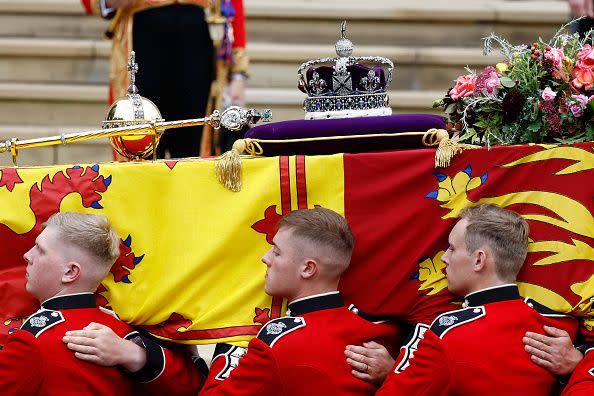 WINDSOR, ENGLAND - SEPTEMBER 19: Pall bearers carry the coffin of Queen Elizabeth II with the Imperial State Crown resting on top to St. George's Chapel on September 19, 2022 in Windsor, England. The committal service at St George's Chapel, Windsor Castle, took place following the state funeral at Westminster Abbey. A private burial in The King George VI Memorial Chapel followed. Queen Elizabeth II died at Balmoral Castle in Scotland on September 8, 2022, and is succeeded by her eldest son, King Charles III. (Photo by Jeff J Mitchell/Getty Images)