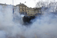 A group of riot police officers advance amid tear gas during a demonstration against plans to push back France's retirement age, Tuesday, Jan. 31, 2023 in Paris. Labor unions aimed to mobilize more than 1 million demonstrators in what one veteran left-wing leader described as a "citizens' insurrection." The nationwide strikes and protests were a crucial test both for President Emmanuel Macron's government and its opponents. (AP Photo/Thibault Camus)