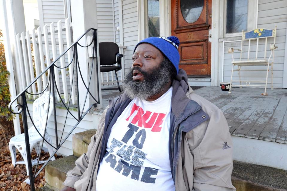 Arthur Dickerson chats with a friend on the front steps of his North Quincy home on Thursday, Dec. 2, 2021.