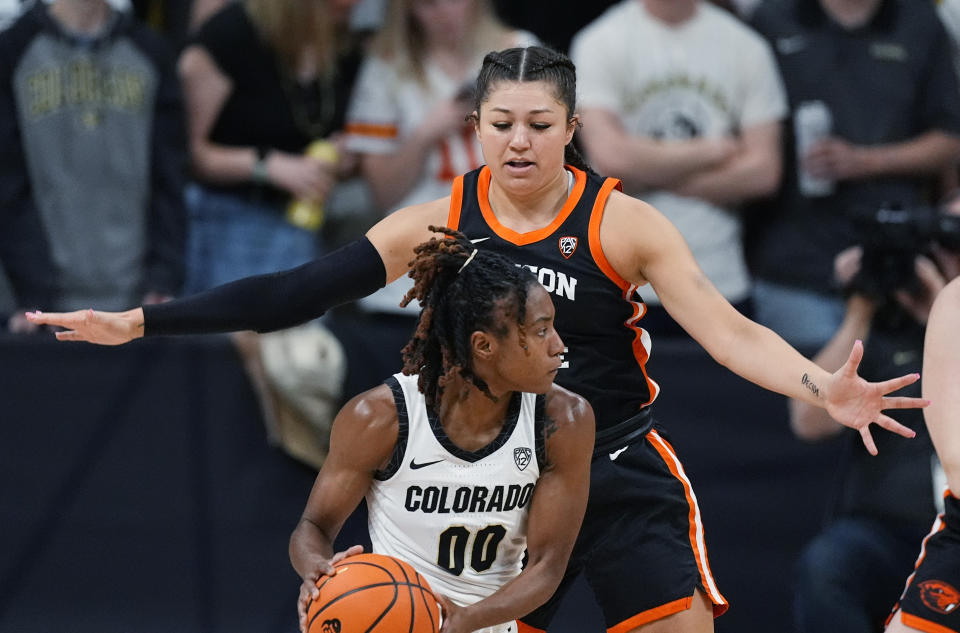 Colorado guard Jaylyn Sherrod (00) looks to pass the ball as Oregon State guard Talia von Oelhoffen, top, defends in the first half of an NCAA college basketball game Sunday, Feb. 11, 2024, in Boulder, Colo. (AP Photo/David Zalubowski)