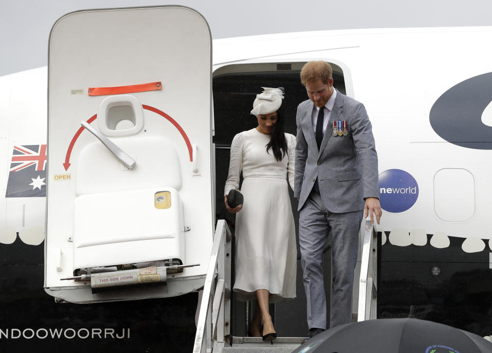 Britain's Prince Harry and Meghan, Duchess of Sussex disembark from their plane on their arrival in Suva, Fiji, Tuesday, Oct. 23, 2018. Prince Harry and his wife Meghan are on day eight of their 16-day tour of Australia and the South Pacific.(AP Photo/Kirsty Wigglesworth,Pool)