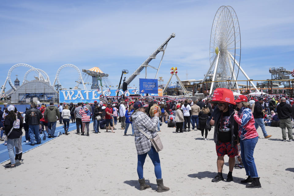Anthony Pahopin, second right, wears an over-sized Donald Trump cap while posing for a photograph before a campaign rally for Republican presidential candidate former President Trump in Wildwood, N.J., Saturday, May 11, 2024. (AP Photo/Matt Rourke)