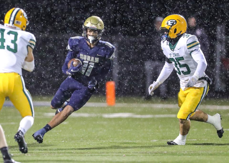 Hoban's Elbert Hill returns a kickoff between St. Edward defenders Bradley Eaton, left, and Behlen Waugh on Friday in Akron.