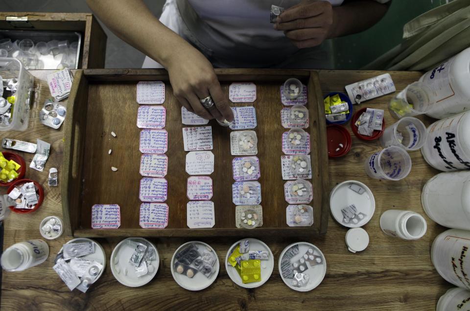 In this May 31, 2013 photo, a nurse prepares medicine for patients at the Neuro-Psychiatric Hospital in Asuncion, Paraguay. Paraguay's only public psychiatric hospital is forced to feed hundreds of patients with donated food for lack of funding. Now, it's running low on medicine. It recently hit a crisis when the hospital couldn't even buy food and there were no psychiatric drugs for ambulatory patients, only inpatients, according to hospital director Teofilo Villalba. (AP Photo/Jorge Saenz)