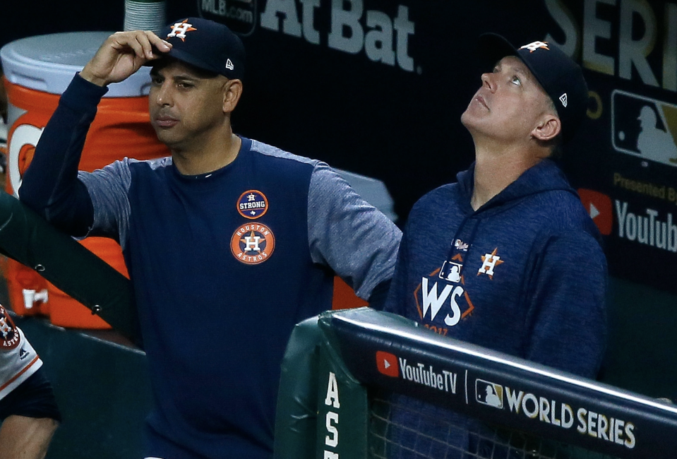 Bench coach Alex Cora #26 and manager A.J. Hinch #14 of the Houston Astros look on from the dugout during the fifth inning against the Los Angeles Dodgers in game five of the 2017 World Series at Minute Maid Park on October 29, 2017 in Houston, Texas. (Photo: Bob Levey/Getty Images)