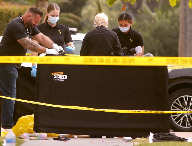 Law enforcement investigate the scene of a stabbing, resulting in the death of two people, in Huntington Beach.