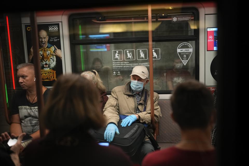 FILE - In this Sept. 12, 2021, an elderly man wearing a face mask and gloves to protect against the coronavirus rides a subway car in Moscow, Russia. When Russians discuss the coronavirus -- from ordinary conversations to remarks even by President Vladimir Putin -- the talk often turns to “antitela.” That's the Russian word for antibodies — the proteins produced by the body to fight infection. (AP Photo/Alexander Zemlianichenko, File)