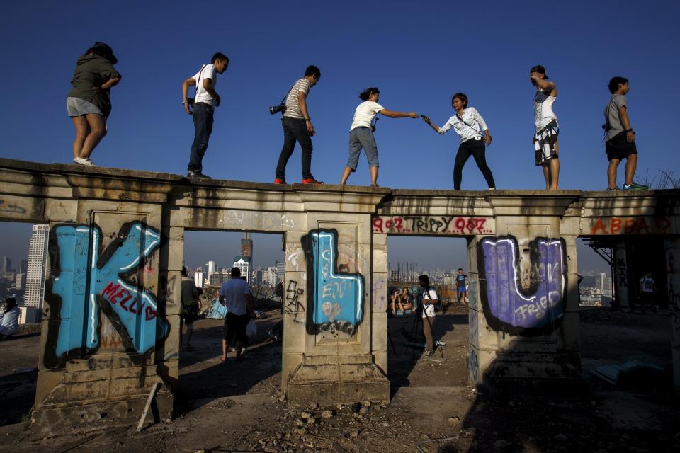 Visitors stand on the roof top of an abandoned building in Bangkok