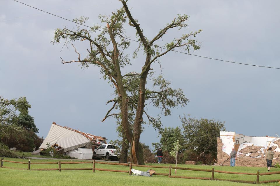 Homeowners look around at the damage after a tornado touched down in Nevada, Iowa on Tuesday, May 21, 2024.