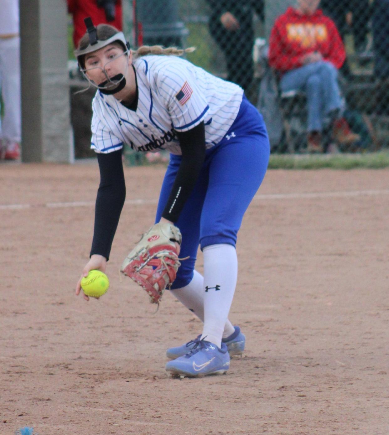 Cambridge First baseman Laney Harper looks to flip the ball to first after fielding a bunt attempt.