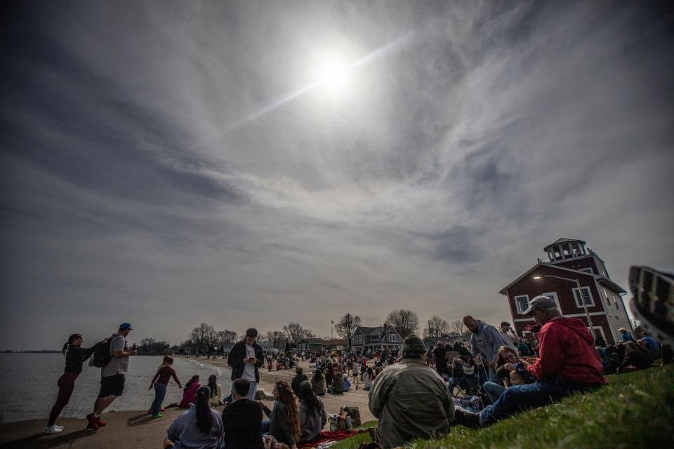 People line the hill near the public to watch the solar eclipse In Luna Pier on Monday, April 8, 2024.