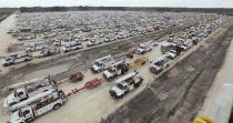 Utility trucks are staged in a rural lot in The Villages of Sumter County, Fla., Wednesday, Sept. 28, 2022. Hurricane Ian rapidly intensified as it neared landfall along Florida's southwest coast Wednesday morning, gaining top winds of 155 mph (250 kph), just shy of the most dangerous Category 5 status. (Stephen M. Dowell/Orlando Sentinel via AP)