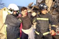 Rescue personnel help a victim at a damaged building after an earthquake in Tainan, southern Taiwan, February 6, 2016. REUTERS/Stringer