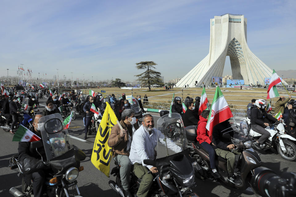 Iranians attend an annual rally at Azadi (Freedom) Square celebrating 42nd anniversary of Islamic Revolution, in Tehran, Iran, Wednesday, Feb. 10, 2021. Iranians Wednesday began a vehicle-only rallies in cities and towns across the country to mark the anniversary of its 1979 Islamic Revolution. The decision for replacing traditional rallies and demonstrations by vehicle-only move came as a measure to prevent spread of the coronavirus as the country struggles to stem the worst outbreak of the pandemic in the Middle East with death toll nearing 59,000 and some 1.48 million confirmed cases of the virus. The country on Tuesday launched a coronavirus inoculation campaign. (AP Photo/Ebrahim Noroozi)