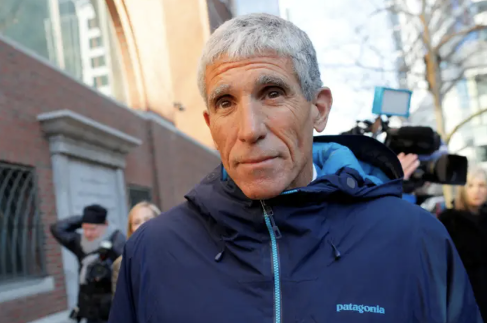 Rick Singer stands outside a courthouse in a patagonia jacket