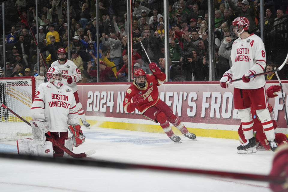 Denver forward Jack Devine (4) celebrates after an overtime win against Boston University in a semifinal game at the Frozen Four NCAA college hockey tournament Thursday, April 11, 2024, in St. Paul, Minn. (AP Photo/Abbie Parr)