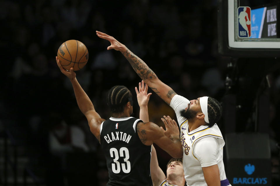 Brooklyn Nets center Nic Claxton, left, is defended by Los Angeles Lakers forward Anthony Thomas during the first half of an NBA basketball game Sunday, March 31, 2024, in New York. (AP Photo/John Munson)