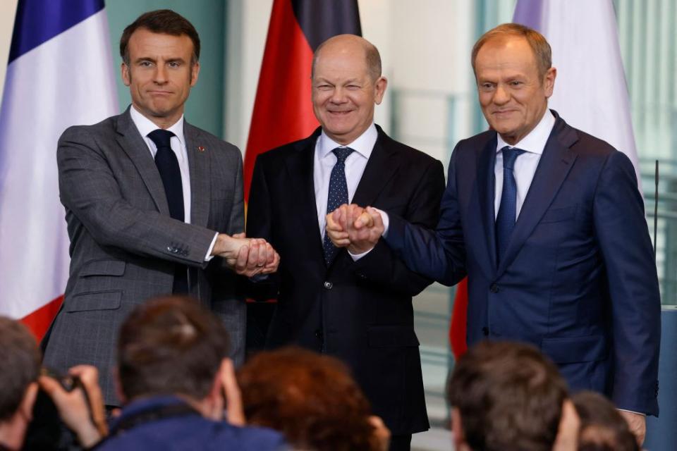 French President Emmanuel Macron (L), German Chancellor Olaf Scholz (C), and Polish Prime Minister Donald Tusk (R) join hands at a press conference amid a meeting of the so-called Weimar Triangle in Berlin, Germany, on March 15, 2024. (Odd Andersen/AFP via Getty Images)