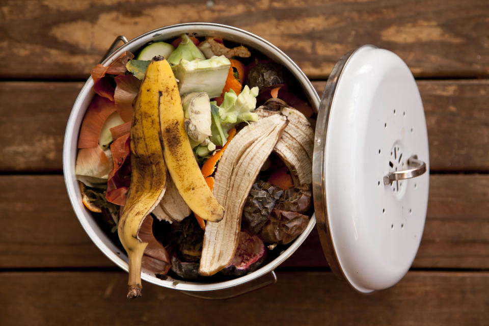 Overhead view of fruit and vegetable scraps in a white enamel container, ready to go in the compost.