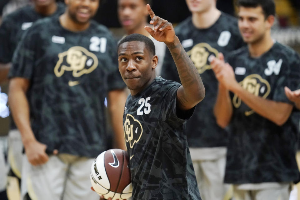 FILE - In this Feb. 25, 2021, file photo, Colorado guard McKinley Wright IV gestures to the small crowd after he received a ball to mark his achievement as the first PAC-12 player to notch 1,600 points, 600 rebounds and 600 assists in his career during a ceremony before an NCAA college basketball game against Southern California in Boulder, Colo. (AP Photo/David Zalubowski, File)