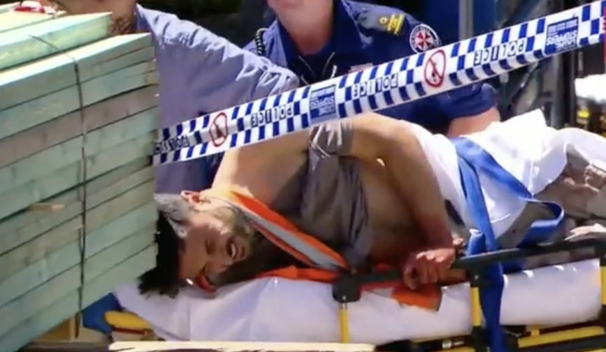 Antony Metledge is seen on a stretcher in pain after a stabbing at a St Peters construction site. 