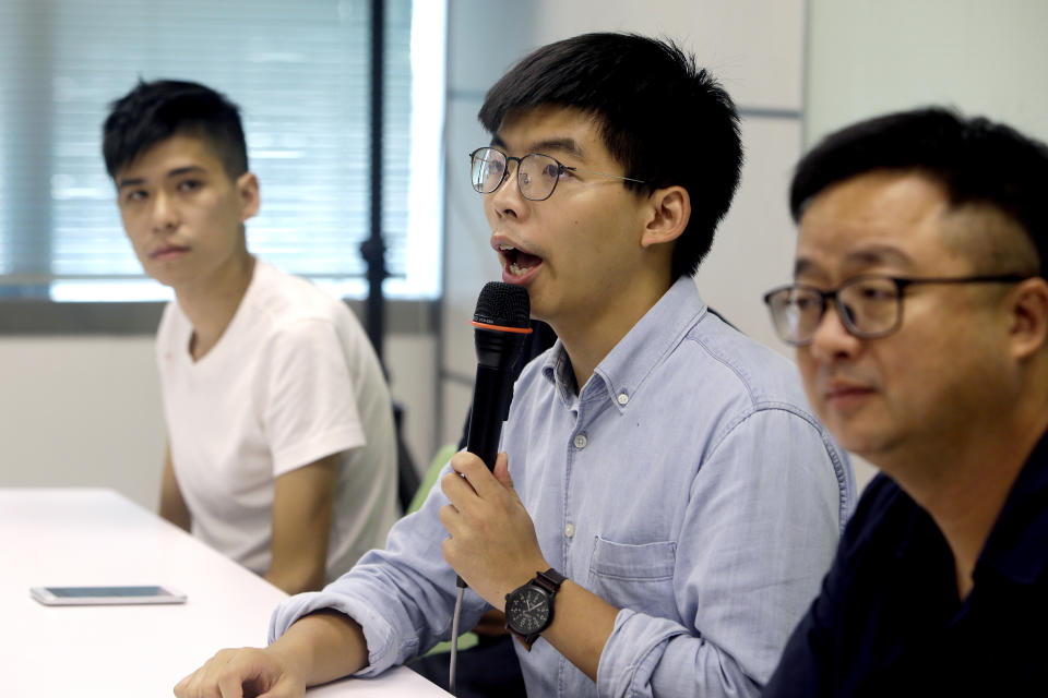 Hong Kong activist Joshua Wong, center, talks to the press with Taiwan Democratic Progressive Party (DPP) Secretary-General Luo Wen-jia, right, after meeting DPP political leaders in Taipei, Taiwan, Tuesday, Sept. 3, 2019. Joshua Wong visits pro-democracy political leaders and joint forum during a two-days trip from Tuesday in Taiwan. (AP Photo/ Chiang Ying-ying)