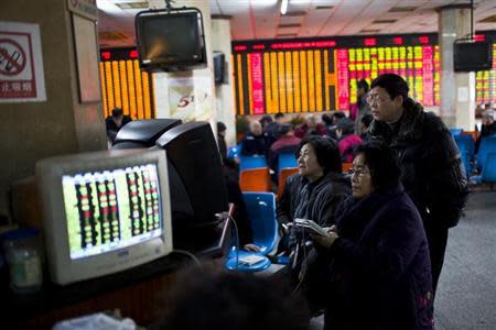 Investors look at computer screens showing stock information at a brokerage house in Shanghai, March 4, 2014. REUTERS/Aly Song