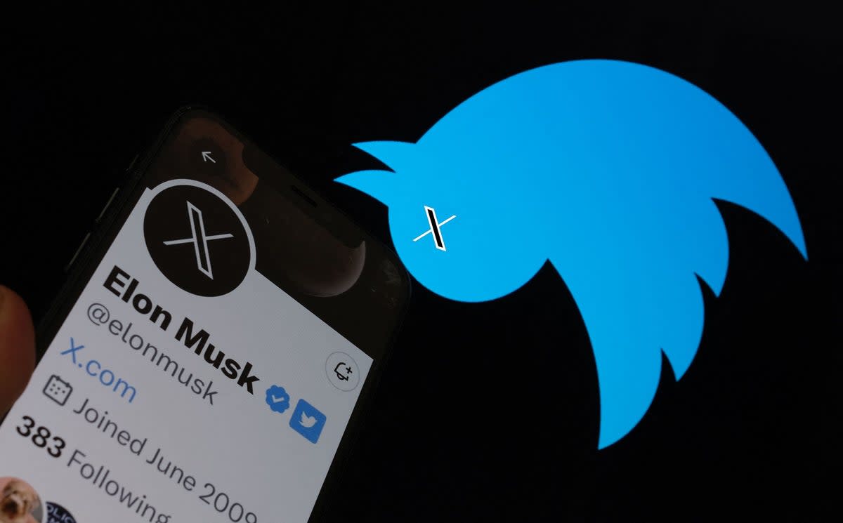 This illustration photo taken on 24 July 2023 shows the Twitter bird logo upside down in the background of Elon Musk’s screen advertising an ‘X’ as a replacement logo (AFP via Getty Images)