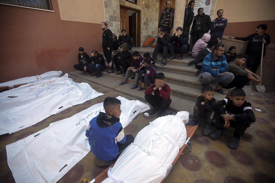 Palestinians mourn relatives killed in the Israeli bombardment of the Gaza Strip outside a morgue in Khan Younis on Friday, Dec. 15, 2023. (AP Photo/Mohammed Dahman)