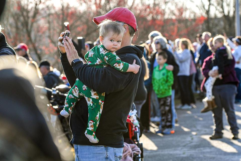 John Case of Elberton, Georgia takes a photos holding his son Cayden, as the US Army Corps of Engineers test spillways of the Hartwell Dam March 13, 2024. The rare occurrence testing the hydropower dam on the Savannah River with a water release draws spectators, many who brought children on the school day for an educational look at the area lake activity. The spill, one gate at a time, lasted two hours.