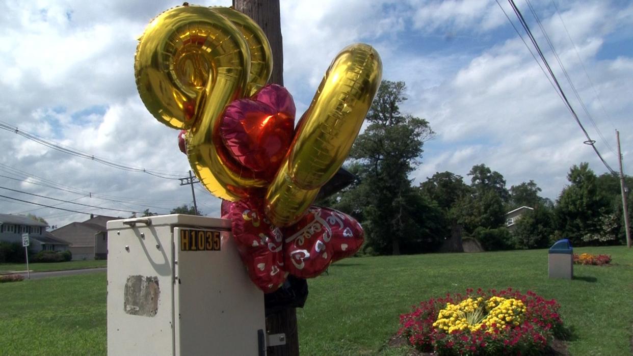 Balloons and flowers mark the scene of a fatal car crash in Long Branch