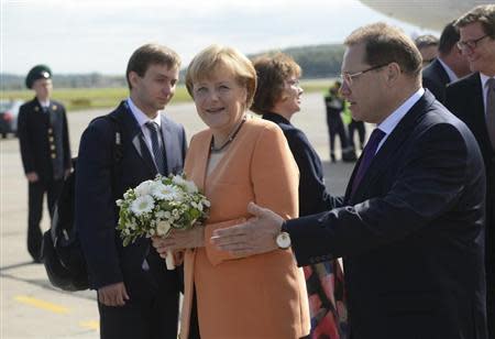 German Chancellor Angela Merkel receives flowers as she arrives to take part in the G20 Summit in St. Petersburg