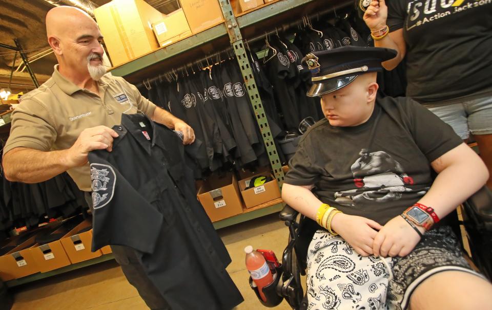 Quartermaster Mel Gherardini picks out a uniform for Jackson Hall prior to the start of his swearing in ceremony Monday morning at the Gastonia Police Department.