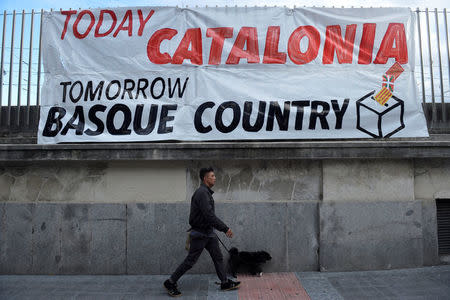 FILE PHOTO: A man walks past a banner during a march organised by pro-Basque independence organization Gure Esku Dago (In Our Hands) in favour of a planned referendum on the independence of Catalonia, in Bilbao, Spain, September 16, 2017. REUTERS/Vincent West/File Photo