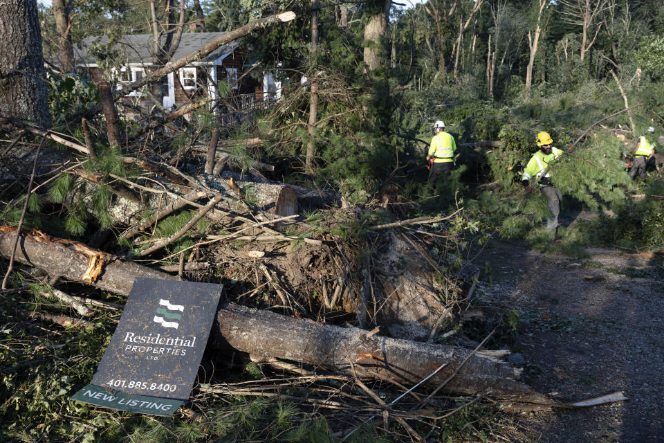 A crew works to clear downed trees, Friday, Aug. 18, 2023, in Scituate, R.I., after severe weather swept through the area. (AP Photo/Michael Dwyer)