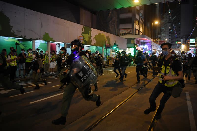 Police officers charge at demonstrators during a protest in Hong Kong