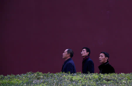 Men walk along a red wall near Tiananmen Gate on the first day of a plenary session of the 18th Central Committee of the Communist Party of China (CPC), in Beijing, China, October 24, 2016. REUTERS/Jason Lee