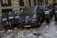 Spanish police stand outside a police station surrounded of objects thrown by pro-independence demonstrators in Barcelona, Spain, Friday, Oct. 18, 2019. Various flights into and out of the region are cancelled Friday due to a general strike called by pro-independence unions and five marches of tens of thousands from inland towns are expected converge in Barcelona's center on Friday afternoon for a mass protest with students to and workers who are on strike. (AP Photo/Bernat Armangue)