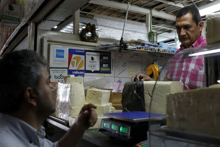 Information for Vippo app and other methods of payment is seen at a cheese and dairy products stall at Chacao Municipal Market in Caracas, Venezuela January 19, 2018. REUTERS/Marco Bello