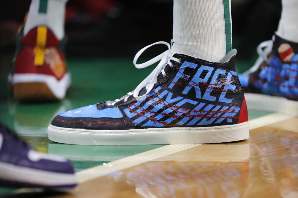 Boston Celtics' Enes Kanter wears shoes with a political message during the first half of an NBA basketball game against the Toronto Raptors, Friday, Oct. 22, 2021, in Boston. (AP Photo/Michael Dwyer)