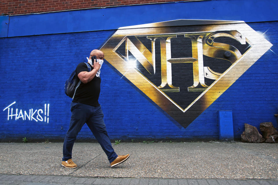 A man walks past an NHS superman graffiti that pays tribute to NHS workers on a wall in Tulse Hill, London, as the UK continues to recover from the coronavirus pandemic.