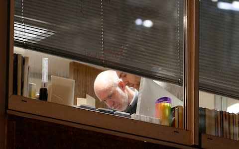 People are seen are seen inside the building which houses the offices of Cambridge Analytica  - Credit: Reuters