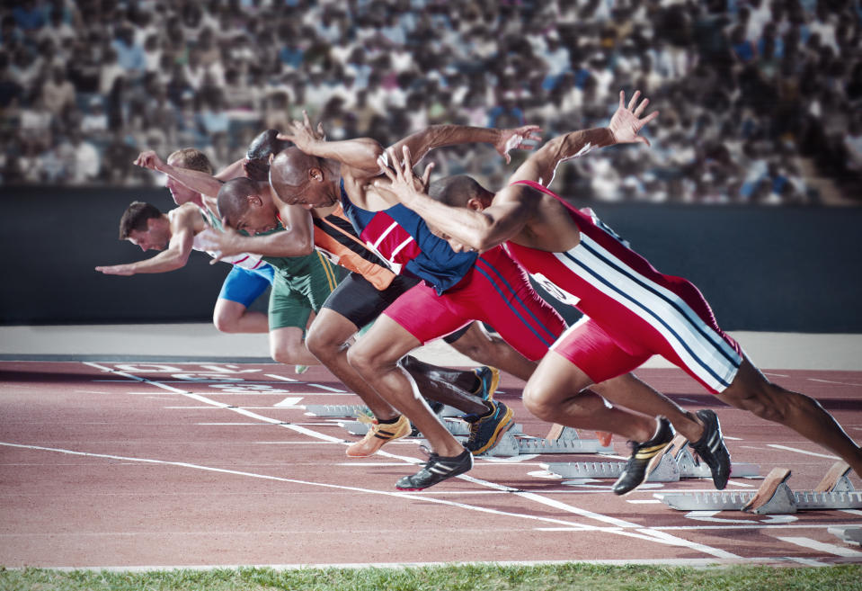 Runners taking off from starting blocks on track