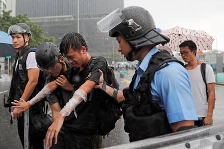 A protester who was pepper sprayed is detained during the anniversary of Hong Kong's handover to China in Hong Kong